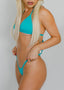 Woman wearing a turquoise bikini against a plain background